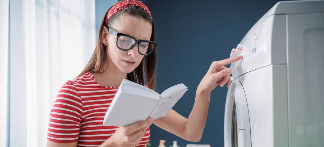 Woman reading her washer manual - How to Use a Frigidaire washing machine