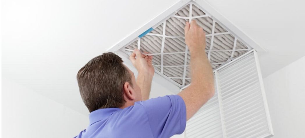 Homeowner installing a new HVAC filter - How to change an HVAC filter