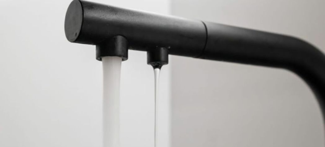 Black faucet with running water - How Everpure PFAS water filtration fights contamination