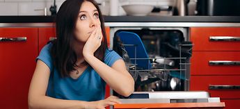 Woman Thinking By Dishwasher