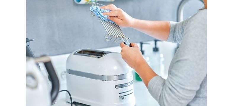 Woman cleaning toaster - How to clean the inside of a toaster 