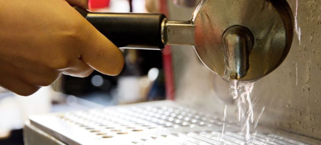 Water running through an espresso tamper - Espresso Machine Maintenance & Cleaning