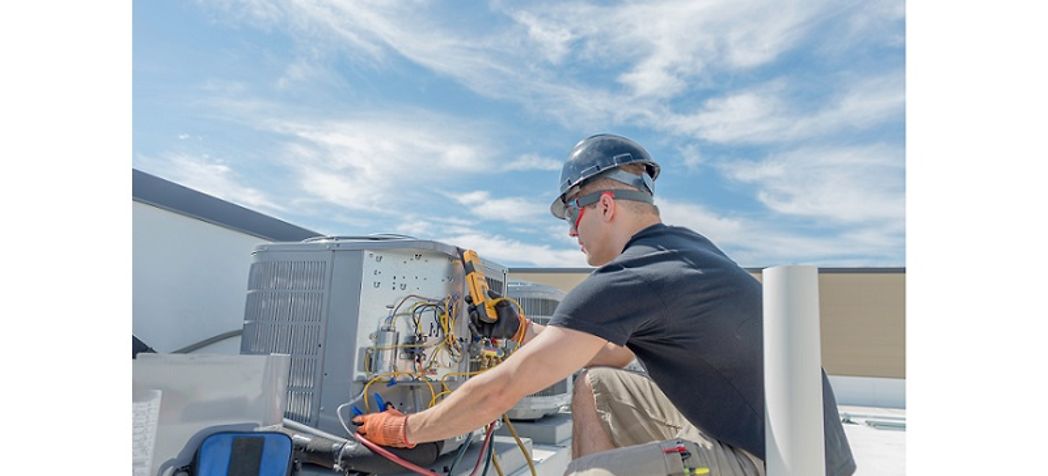 Service technician repairing a rooftop unit - Aaon rooftop unit troubleshooting and alarm codes