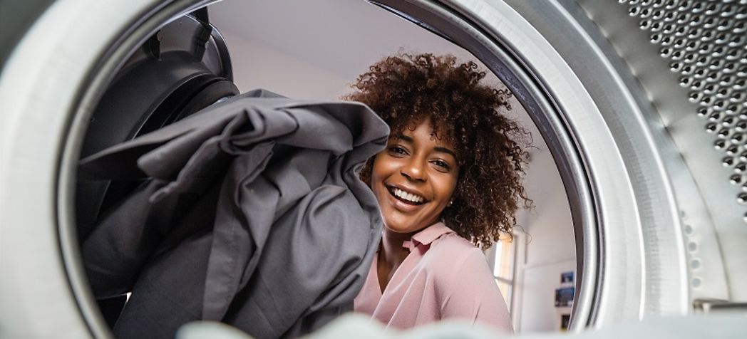 Women smiling while doing laundry - Speed Queen Commercial Dryer Troubleshooting
