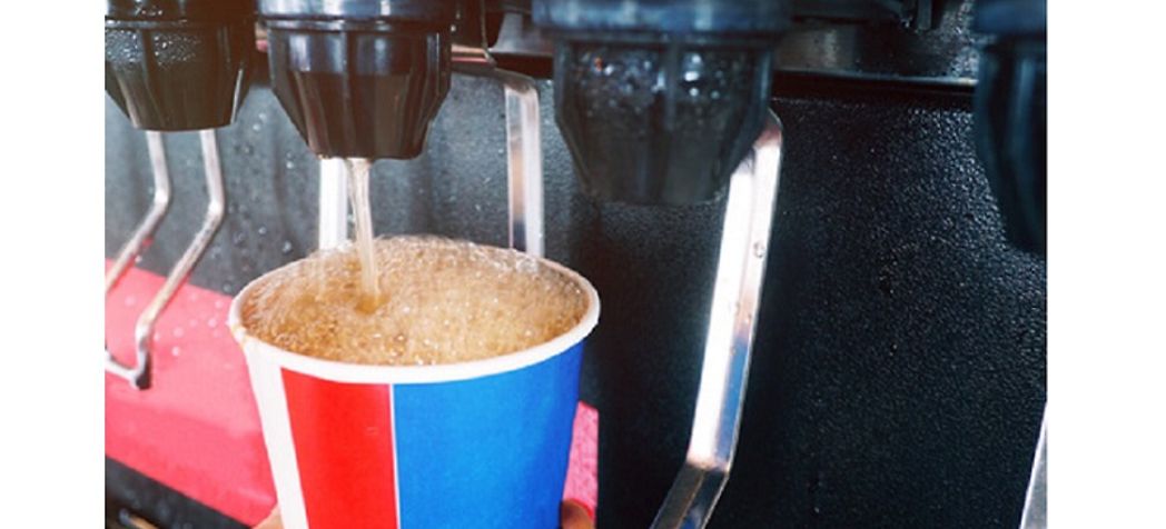 Employee dispensing soda into a paper cup - Lancer beverage brix adjustment instructions