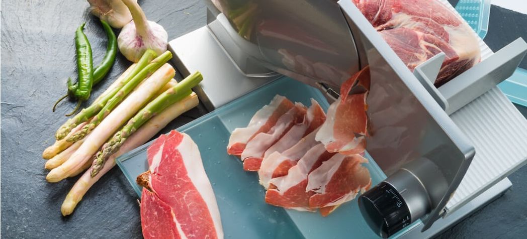 Chef thinly slicing a cut of pork - How to use a Berkel meat slicer