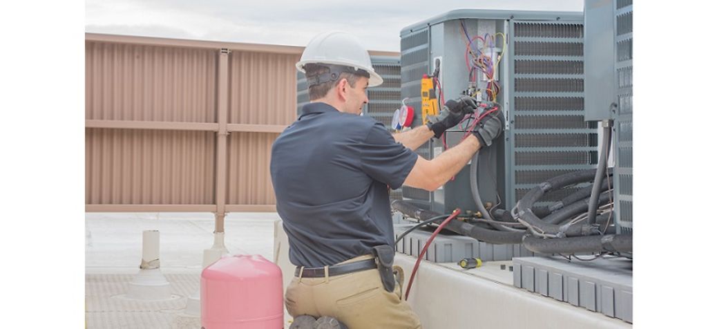 HVAC technician repairs condenser - York Rooftop Unit Troubleshooting Guide