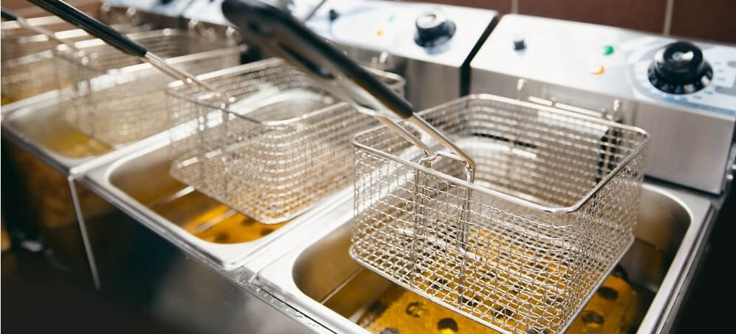 Fryer baskets hanging over tank on commercial fryer - Garland fryer troubleshooting 