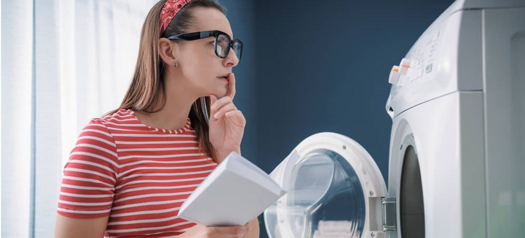 Woman reading the user manual for her washer - How to use a Speed Queen washing machine
