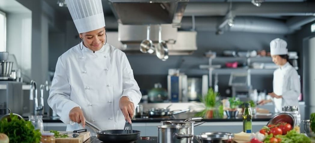Female chef cooking food on the commercial range - Electrolux induction range troubleshooting