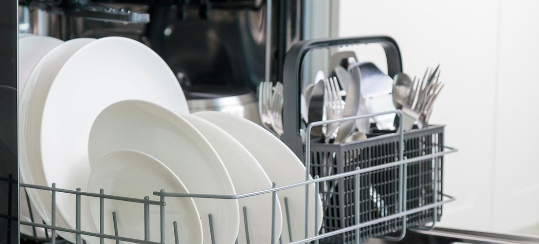 Opened dishwasher machine with clean dishes - How to Choose a Dishwasher