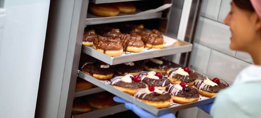 Woman pulling donuts out of the oven - Adamatic Belshaw Ecotouch Convection Oven Troubleshooting