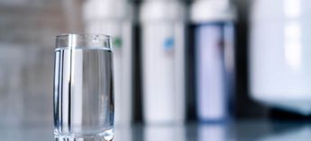 Glass of water with filters in the background - how do I change an Everpure water filter