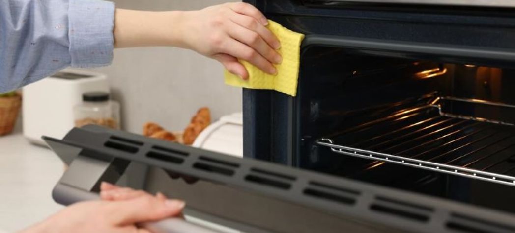 Woman cleaning an oven with a rag - adamatic belshaw ecotouch convection oven cleaning