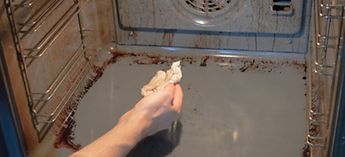 Mans arm wiping down the interior of a dirty oven - how to clean and maintain a blodgett invoq oven