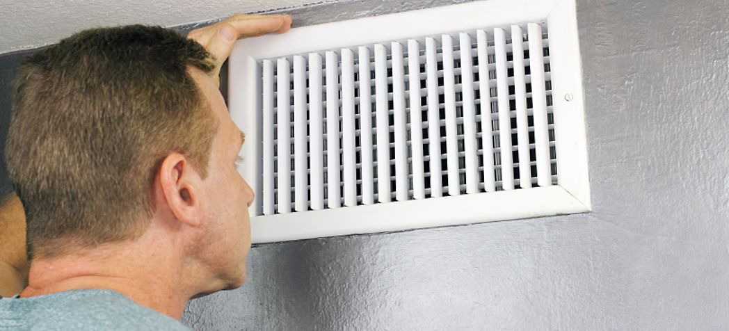 Arcoaire Furnace Troubleshooting - Man Looking in HVAC Air Vent - Troubleshooting Guide