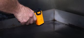 Hand with a temperature gun - garland griddle calibration instructions