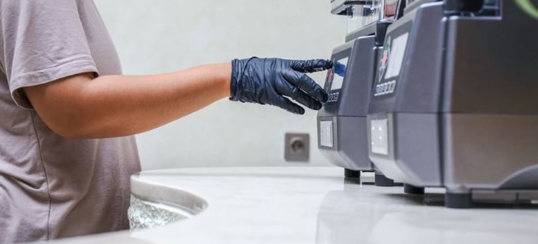 gloved hand starting machine - spaceman smoothie machine cleaning