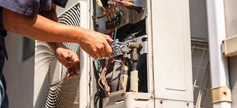 technician performing maintenance on hvac unit - what do mechanical contractors do